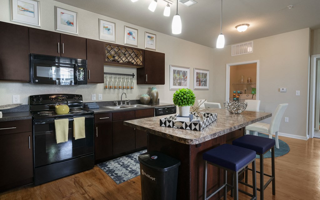 a kitchen with a large island with a granite countertop