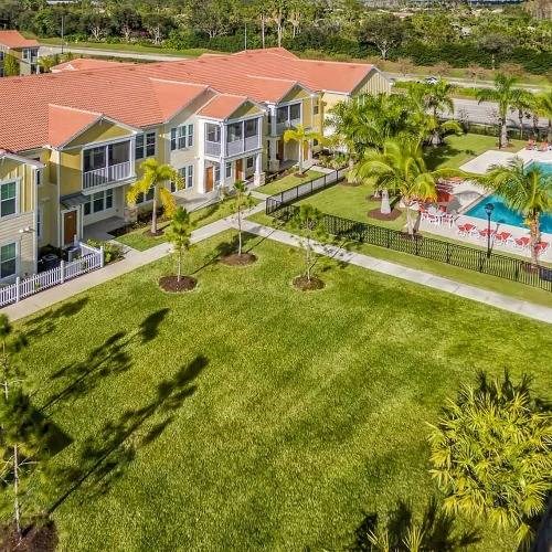 a yard with a pool and houses in the background