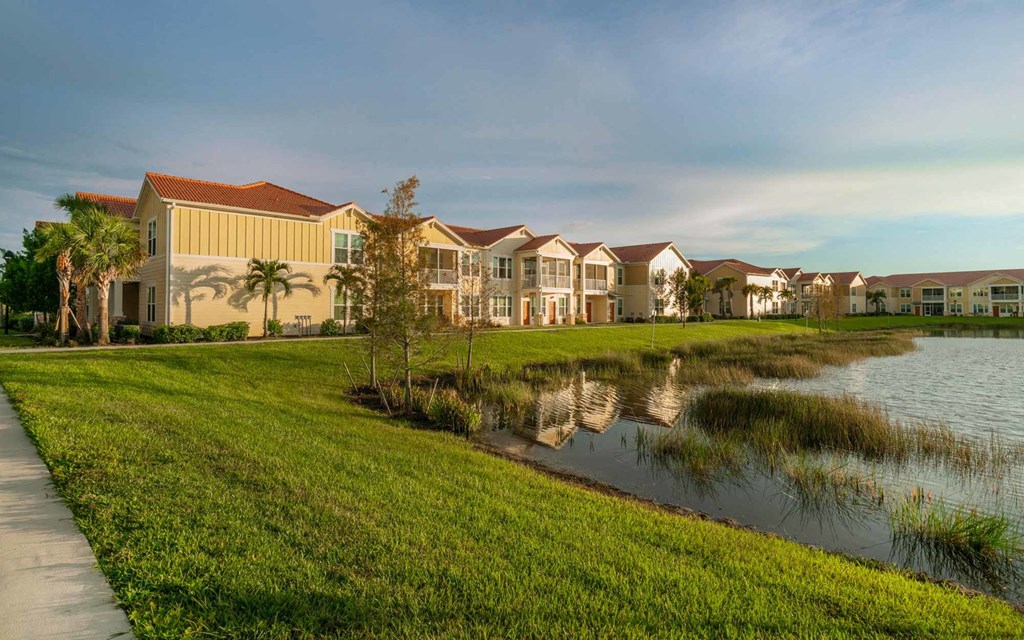 a small body of water sits in front of a row of houses