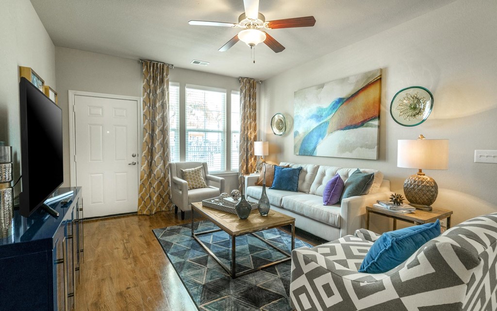 a living room with a ceiling fan and hardwood flooring