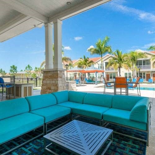 a patio with a blue couch and a coffee table