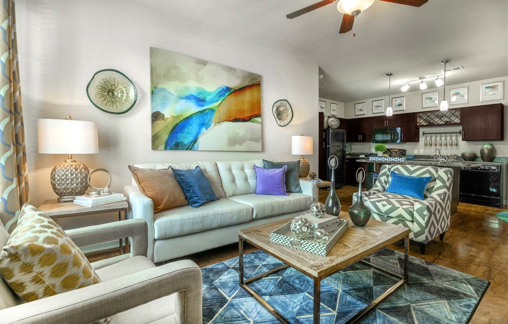 a living room filled with furniture and a ceiling fan
