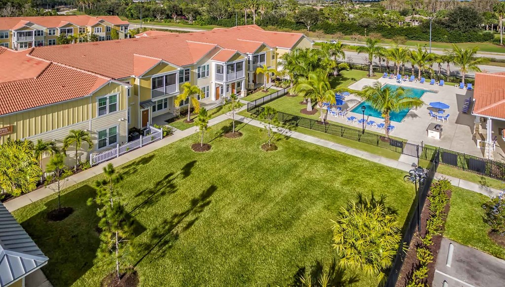an aerial view of a group of houses with a pool in the background