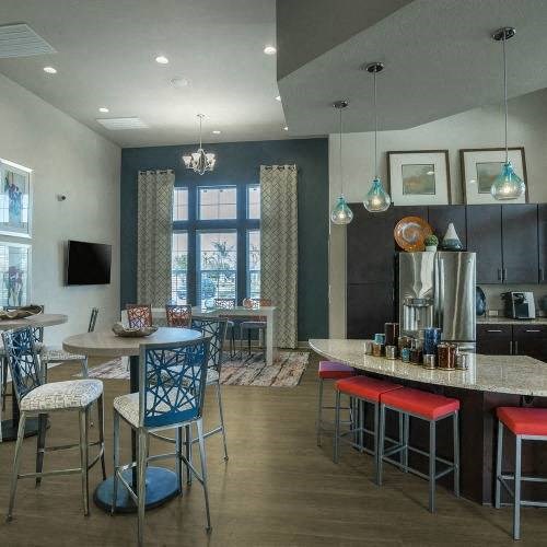 a kitchen with a counter and chairs and a refrigerator