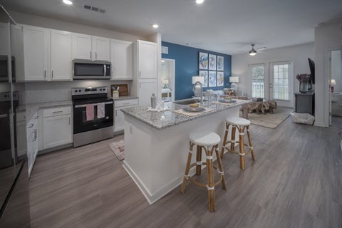 a kitchen with white cabinets and a marble counter top