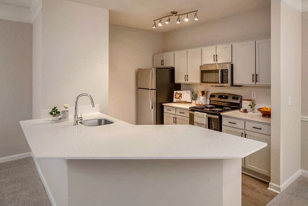 a kitchen with a white counter top and a sink
