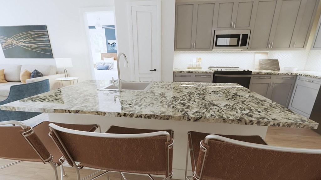 a kitchen with a large island and a living room in the background