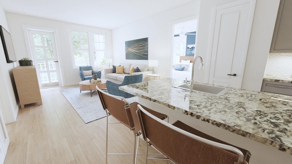 a kitchen with an island and a living room in the background