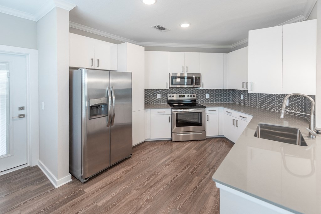 a kitchen with white cabinets and stainless steel appliances at Verso Apartments, Florida, 33896