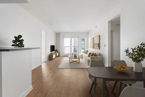 A modern living room with a dining table and chairs.