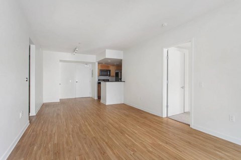 A spacious room with wooden floors and white walls.