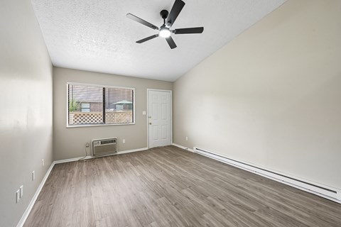 A room with a ceiling fan and a window with blinds.