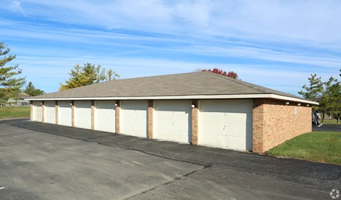 A building with a brown roof and white garage doors.