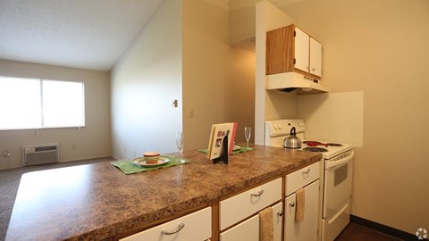 A kitchen with a brown counter top and white cabinets.