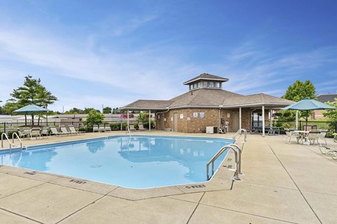 A large outdoor swimming pool with a pavilion in the background.