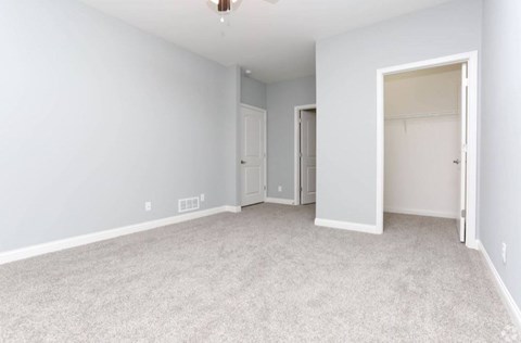A spacious room with carpeted floor and white walls.