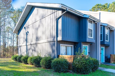 A blue house with a white door and windows.