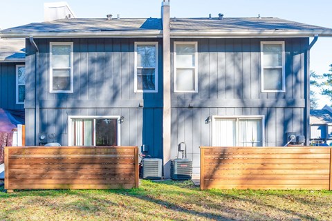 A grey house with a wooden fence in front.
