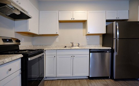 A kitchen with white cabinets and a black stove top oven.