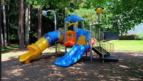 A playground with a blue and yellow slide.