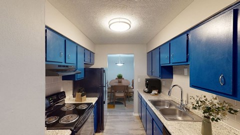 A kitchen with blue cabinets and a black stove top.