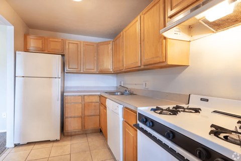 A kitchen with a white refrigerator and a white stove top oven.