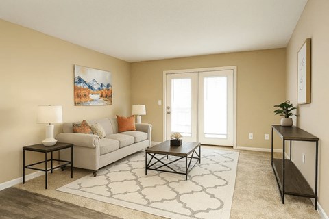 A living room with a grey couch, a coffee table, and a painting on the wall.
