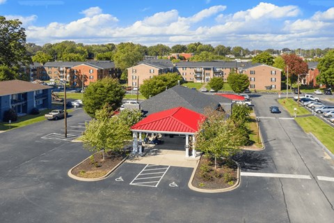 A parking lot with a red-roofed building in the middle.
