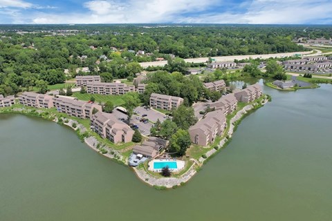 A bird's eye view of a resort with a swimming pool surrounded by water.