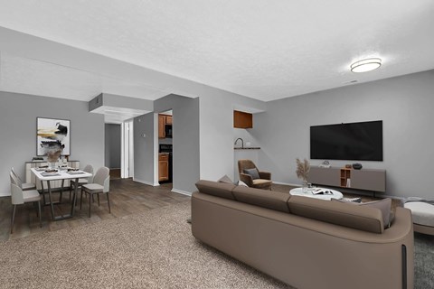A living room with a brown couch and a dining table.
