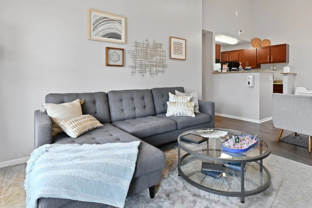 A grey couch with a blue blanket on it in a living room.