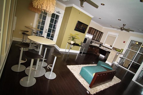A living room with a green couch and a dining table with chairs.