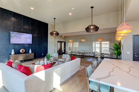 A modern living room with a white couch and a television on the wall.