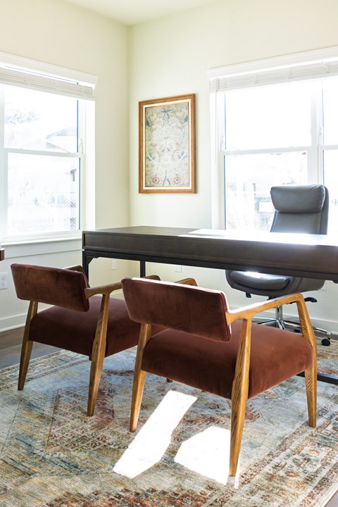A room with a table and chairs and a picture on the wall.