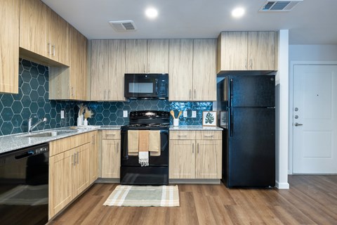 A kitchen with wooden cabinets and black appliances.