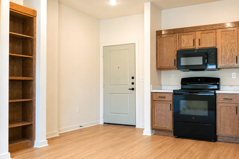 A kitchen with wooden cabinets and appliances.