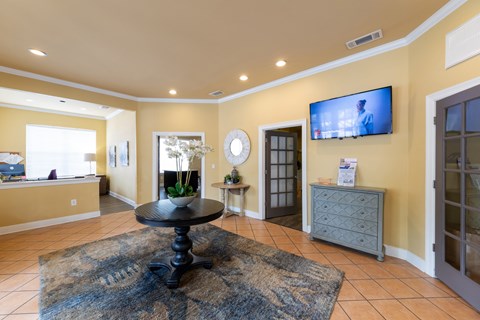 A living room with a black table in the middle of a rug.
