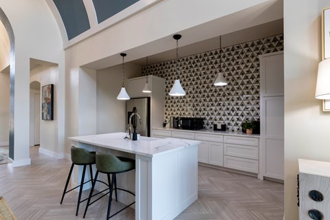 A kitchen with a white counter and green bar stools.