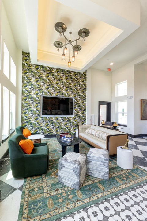 A living room with a green chair and a patterned wallpaper.