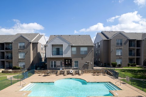 A large swimming pool in front of apartment buildings.