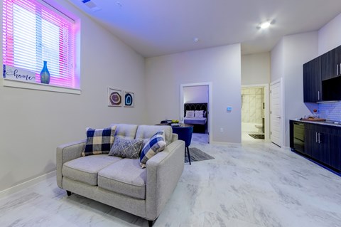 A living room with a couch and a window with blinds.