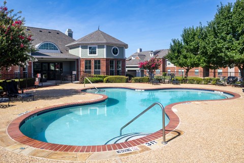 A swimming pool with a brick border and a slide.