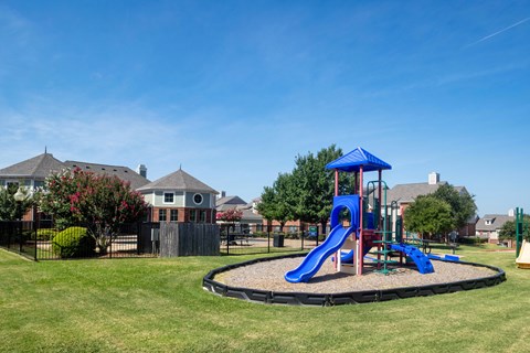 A playground with a blue slide and a blue canopy.