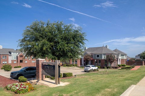 A sign that says "Tower Ridge" stands in front of a building.