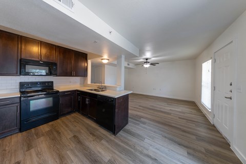 A kitchen with dark wood cabinets and a black stove top oven.