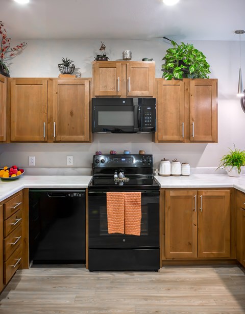 A kitchen with wooden cabinets and a black stove top oven.