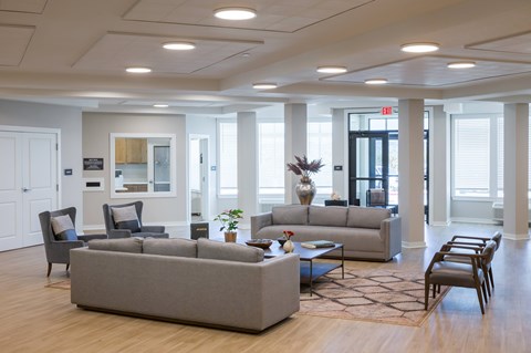 A spacious living room with a grey sofa set and a coffee table.