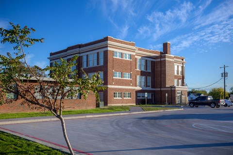 A red brick building with a tree in front of it.