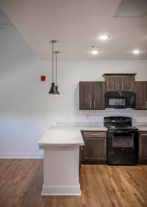 A kitchen with a white counter top and dark brown cabinets.