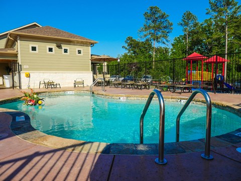 A small pool with a slide and a playground.